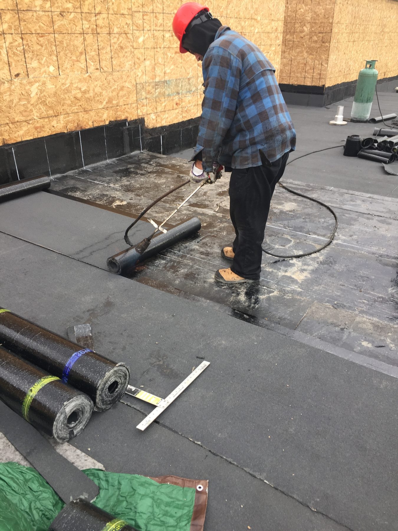 Modified bituminous membrane being installed on a low-slope roof