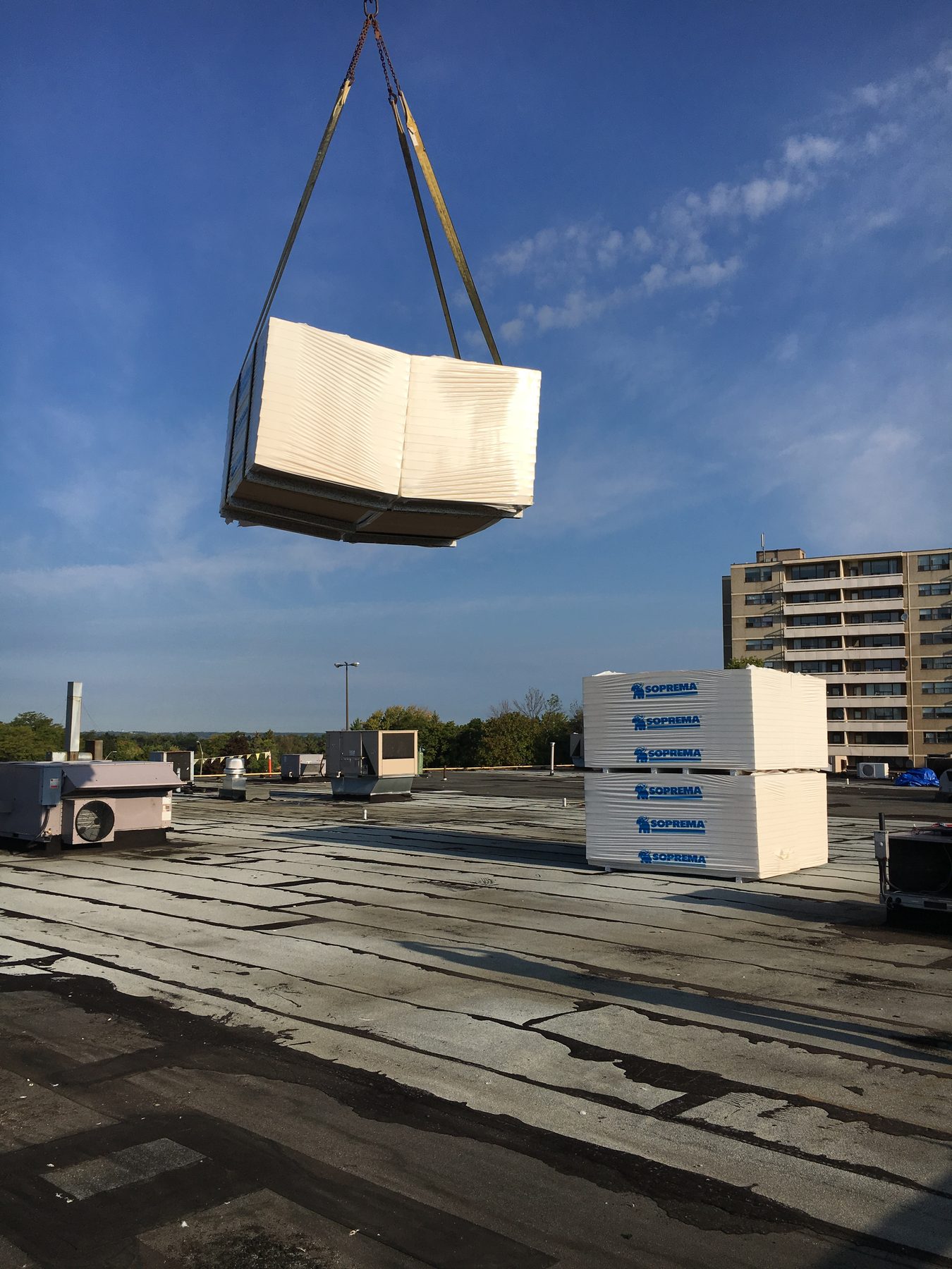 Roofing materials being lifted to a commercial roof